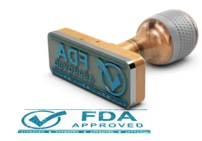 A stamp with a checkmark and the word FDA approved lying on its side on a white background.